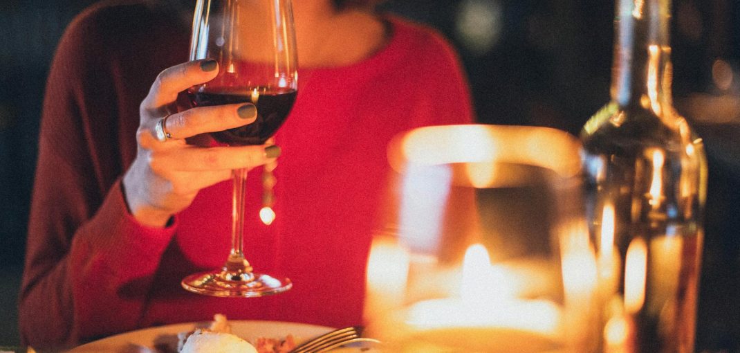 woman holding wine glass selective focus photography